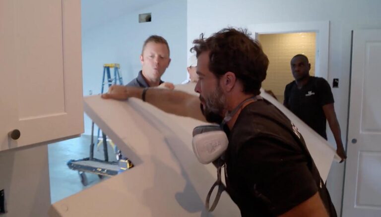 David Shoultz and the crew carrying a countertop slab into a kitchen during filming